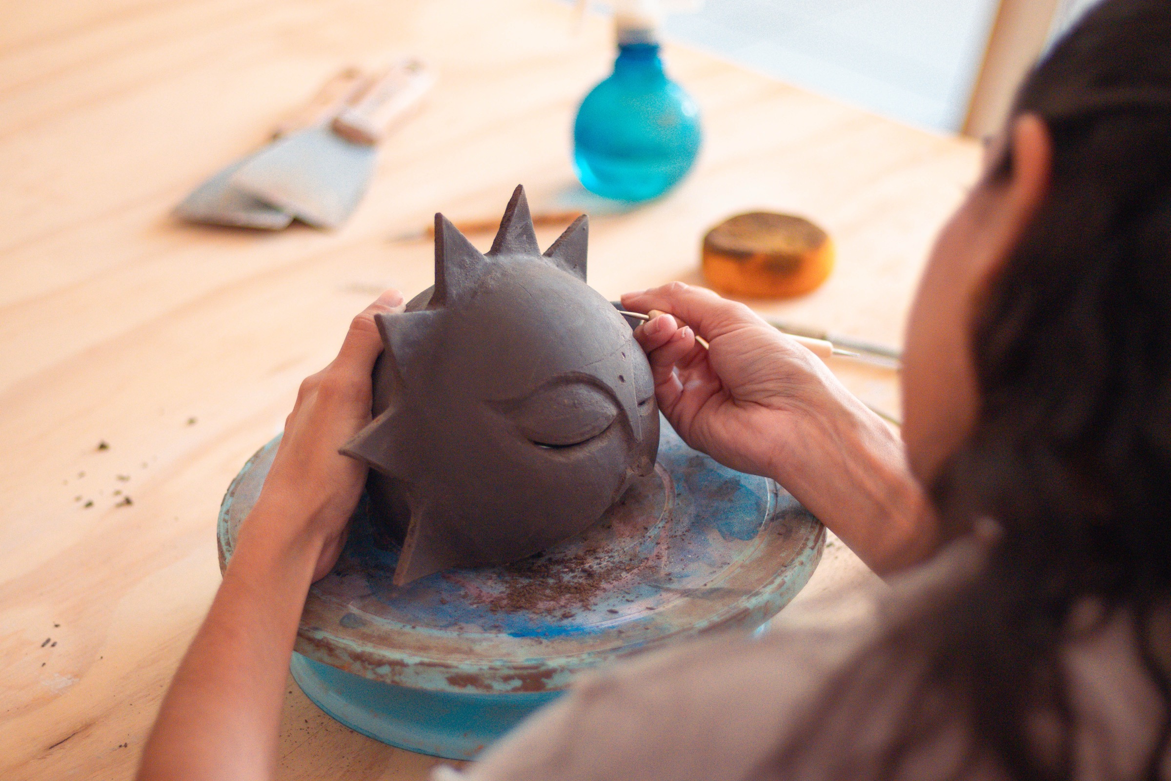 Persona modelando una escultura de cerámica en el estudio